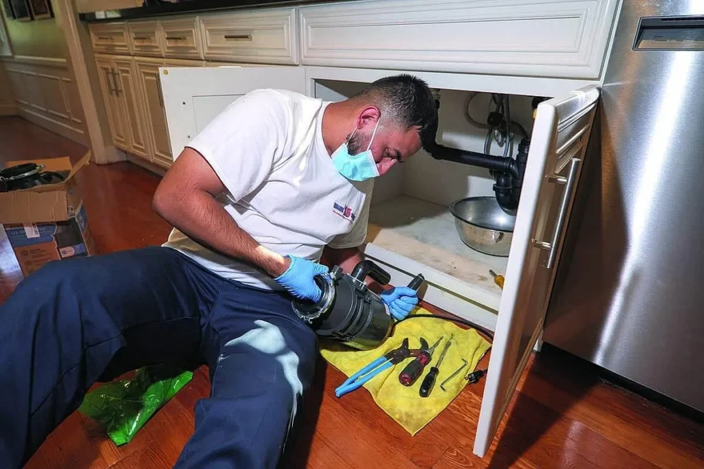 Charlie Morales replaces a garbage disposal in a residence.